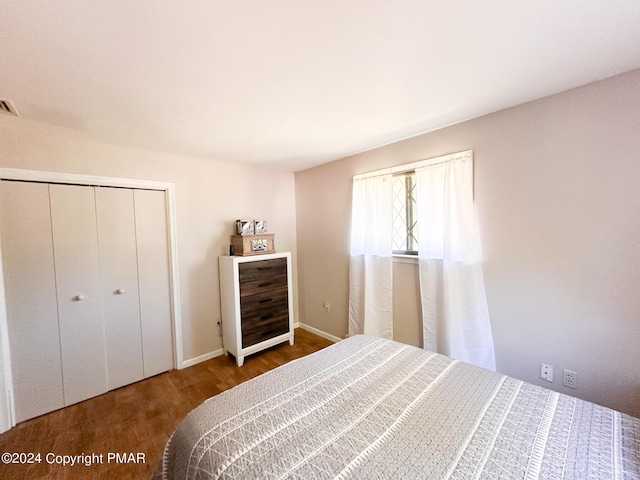 bedroom with a closet, visible vents, and wood finished floors