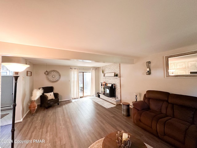 living area with a baseboard radiator, wood finished floors, and baseboards