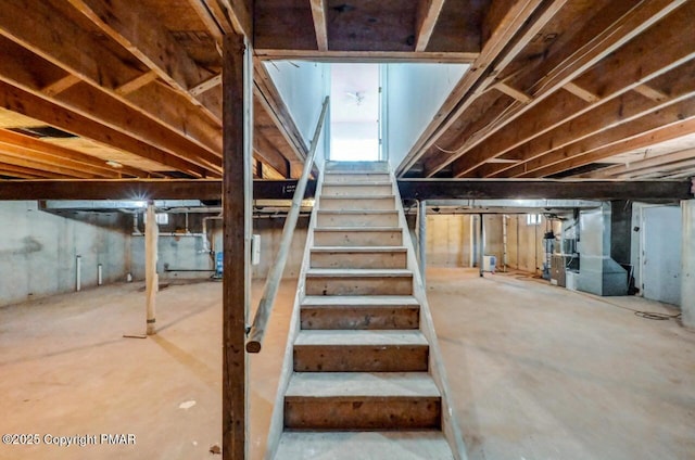 unfinished basement featuring heating unit and stairs