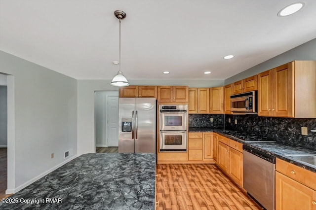 kitchen with light wood-style floors, visible vents, appliances with stainless steel finishes, and backsplash