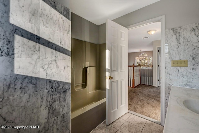 full bath with tile patterned flooring, vanity, and an inviting chandelier