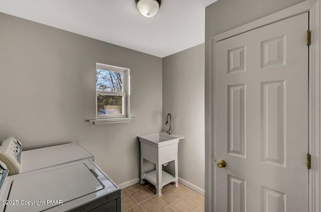 laundry room with laundry area, light tile patterned flooring, baseboards, and washing machine and clothes dryer