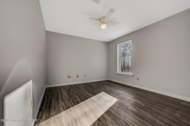 empty room with a ceiling fan, baseboards, and wood finished floors