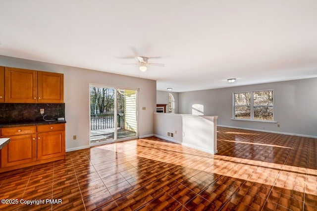 kitchen with dark wood-style floors, brown cabinets, and backsplash