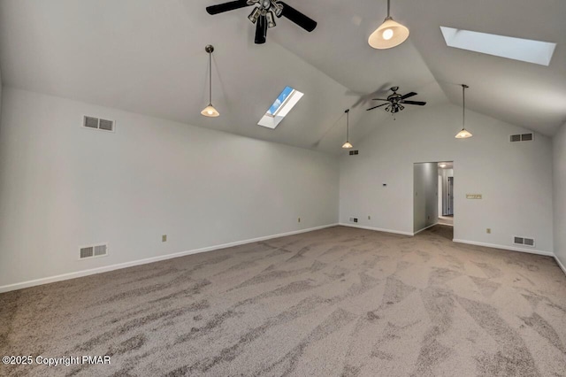 empty room with lofted ceiling with skylight, ceiling fan, and visible vents