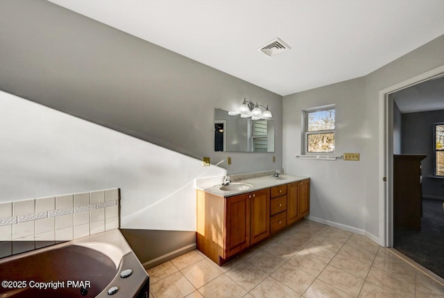 bathroom featuring a bathing tub, visible vents, a sink, and tile patterned floors