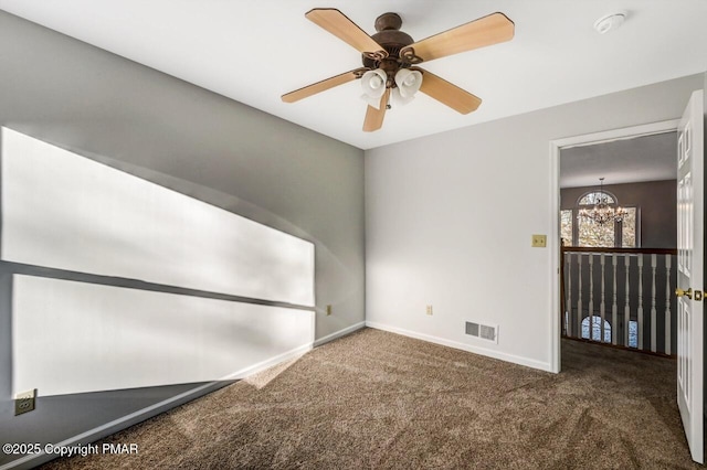 carpeted empty room featuring a chandelier, visible vents, and baseboards