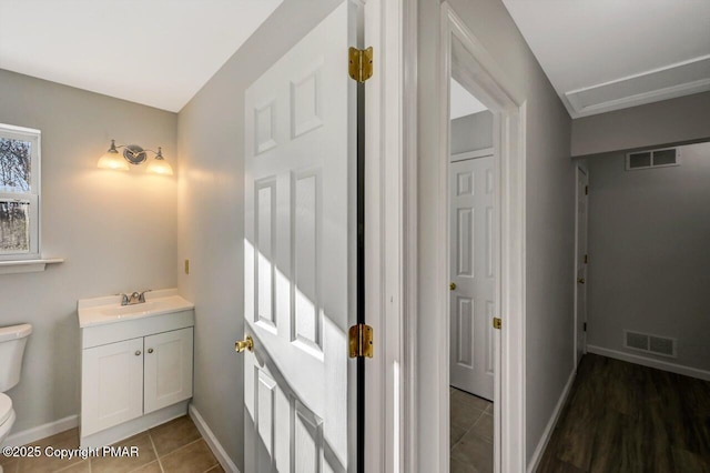 bathroom with baseboards, visible vents, vanity, and toilet