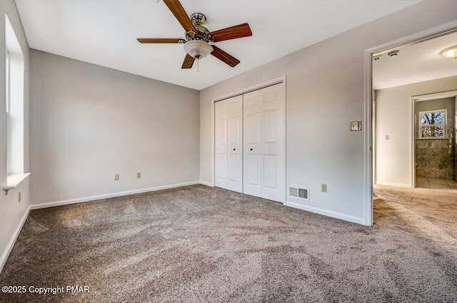 unfurnished bedroom with ceiling fan, carpet floors, visible vents, baseboards, and a closet