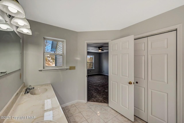 bathroom with double vanity, tile patterned flooring, baseboards, and a sink