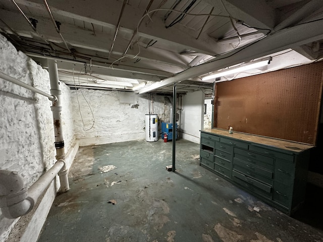 unfinished below grade area featuring a workshop area and electric water heater