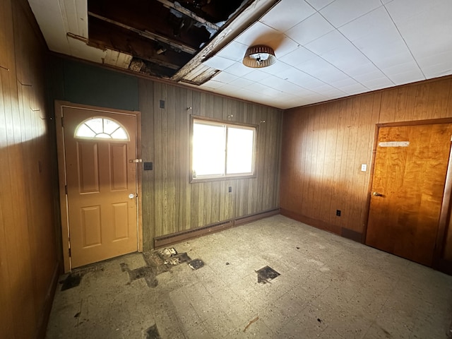 foyer entrance featuring tile patterned floors and wood walls