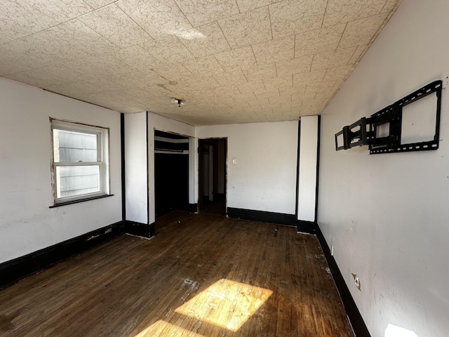 unfurnished bedroom featuring baseboards and hardwood / wood-style flooring