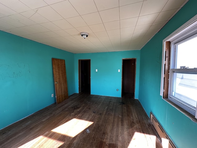 spare room with a baseboard radiator and wood finished floors