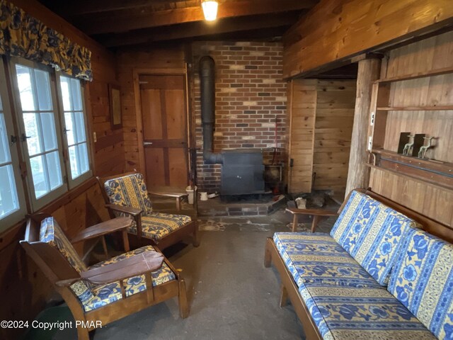 living area featuring a wood stove and wooden walls
