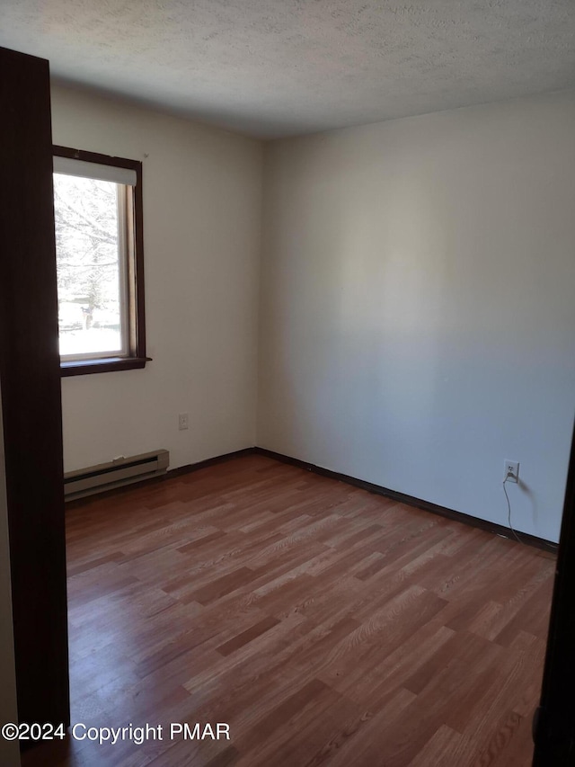 1584 Black Birch Way, Tobyhanna, PA 18466 - empty room with baseboard heating, wood finished floors, and a textured ceiling