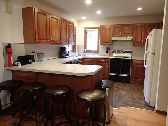 138 Banbury Dr, Bushkill, PA 18324 - kitchen featuring electric stove, under cabinet range hood, freestanding refrigerator, a peninsula, and recessed lighting