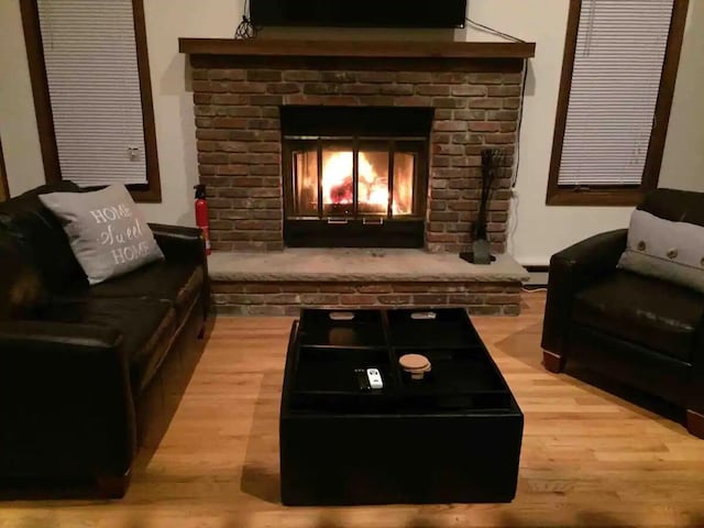 138 Banbury Dr, Bushkill, PA 18324 - living area with wood finished floors, a baseboard heating unit, and a brick fireplace
