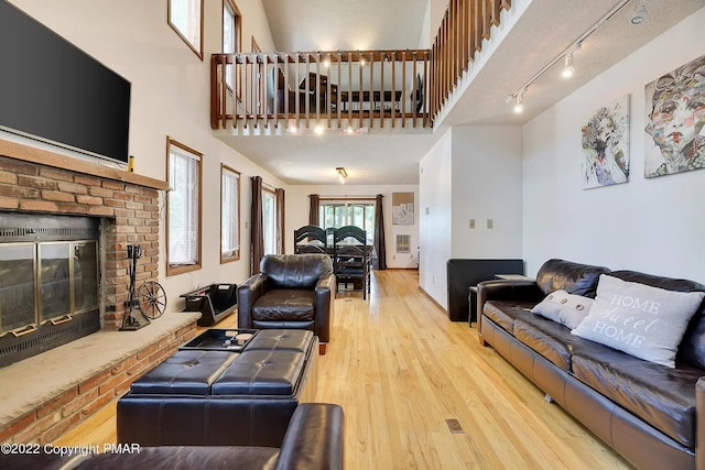138 Banbury Dr, Bushkill, PA 18324 - living room featuring a brick fireplace, wood finished floors, and a high ceiling