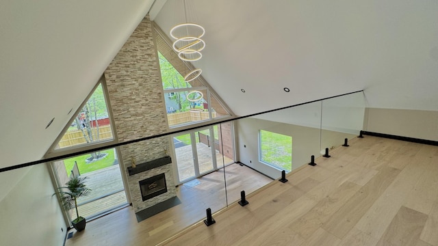 2154 Valleyview Dr, Bushkill, PA 18324 - staircase featuring a high ceiling, a chandelier, wood finished floors, a stone fireplace, and baseboards