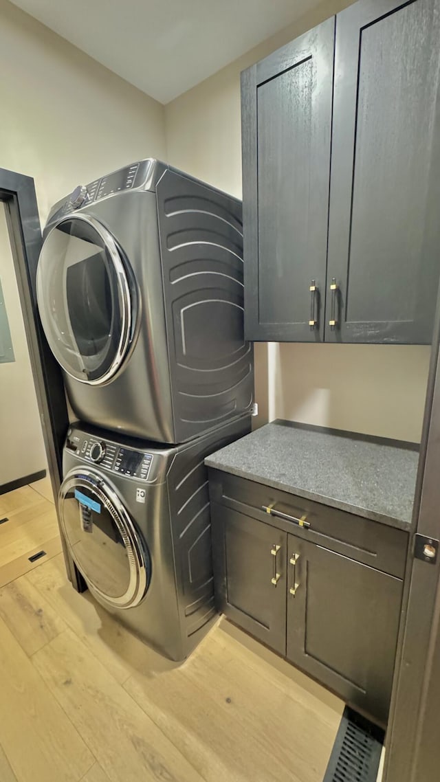 2154 Valleyview Dr, Bushkill, PA 18324 - laundry room featuring cabinet space, stacked washing machine and dryer, and light wood-style flooring