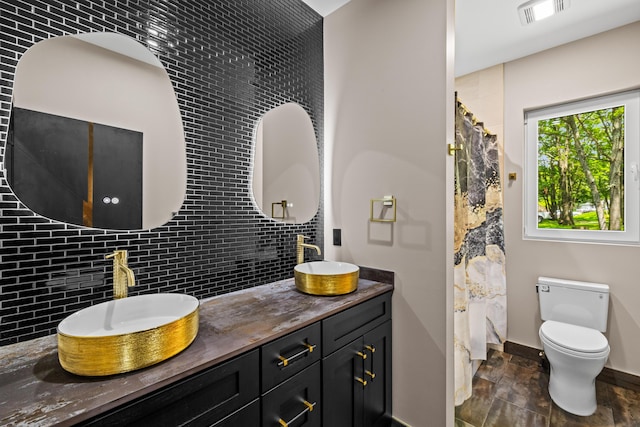 2154 Valleyview Dr, Bushkill, PA 18324 - bathroom with decorative backsplash, double vanity, stone finish floors, and toilet