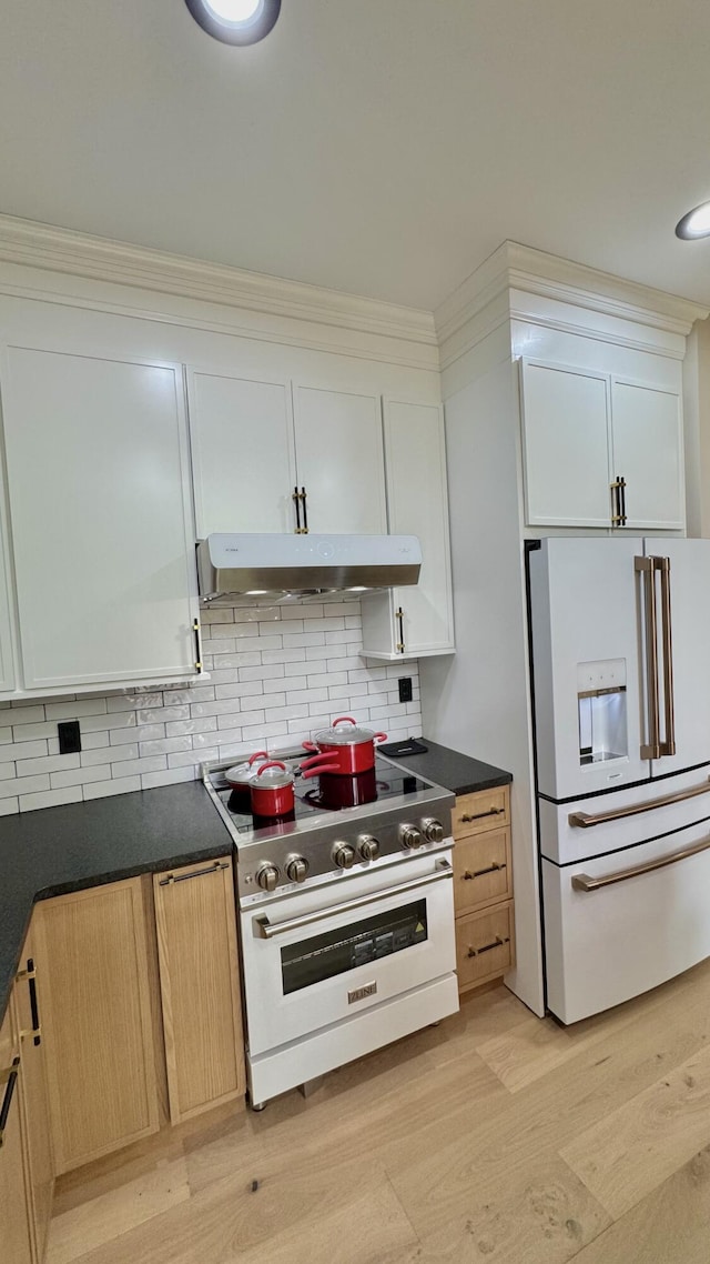 2154 Valleyview Dr, Bushkill, PA 18324 - kitchen with white refrigerator with ice dispenser, high quality range, under cabinet range hood, dark countertops, and tasteful backsplash