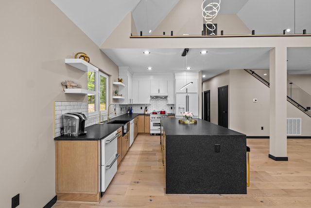 2154 Valleyview Dr, Bushkill, PA 18324 - kitchen featuring premium appliances, dark countertops, a sink, open shelves, and light wood-type flooring