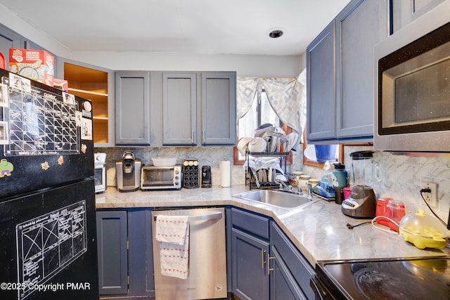 kitchen with sink, backsplash, gray cabinets, and stainless steel appliances