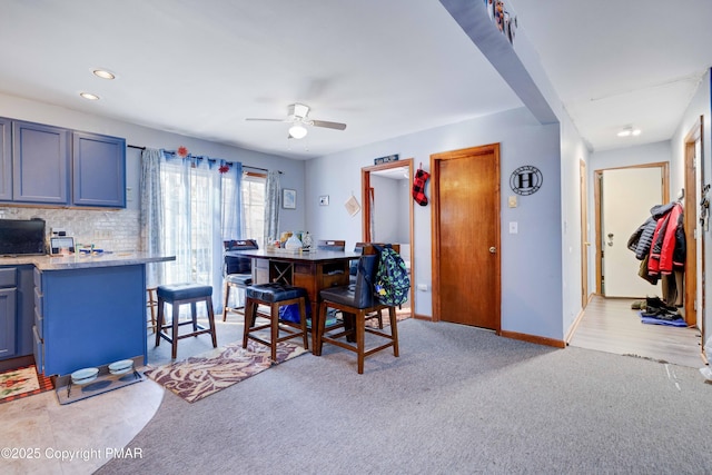 dining area featuring light carpet and ceiling fan