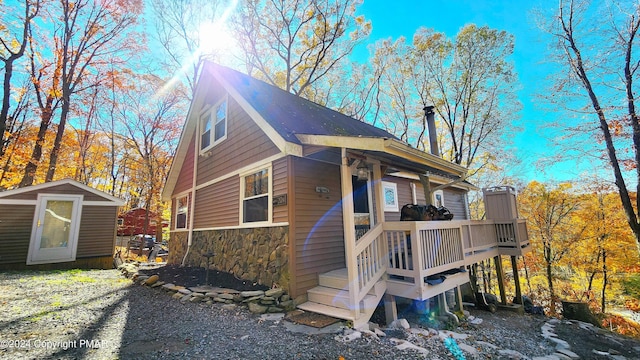 view of home's exterior featuring an outdoor structure, a storage unit, and stone siding