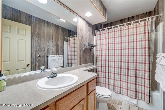 full bath with shower / bath combination with curtain, toilet, wooden walls, vanity, and wood finished floors