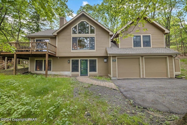 view of front of house with aphalt driveway, roof with shingles, a chimney, an attached garage, and a front lawn