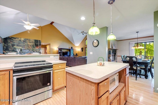 kitchen featuring white microwave, light wood-style floors, electric stove, light countertops, and a center island