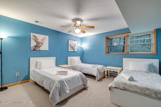 carpeted bedroom with a ceiling fan, baseboards, visible vents, and a textured ceiling