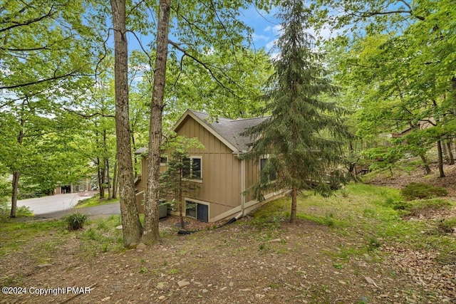 view of side of property with roof with shingles