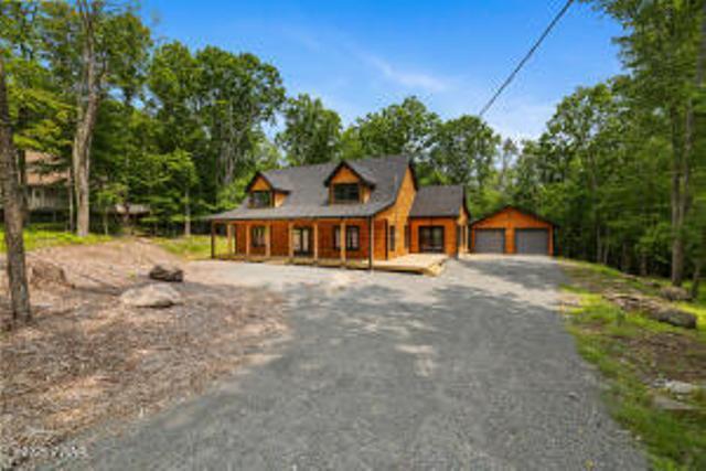 118 Eagle Rock Rd, Lackawaxen, PA 18435 - rustic home featuring a porch, a garage, and an outdoor structure
