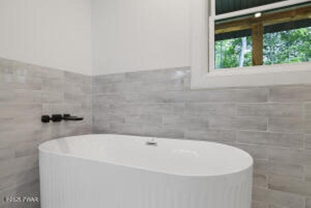 118 Eagle Rock Rd, Lackawaxen, PA 18435 - full bath featuring tile walls, a soaking tub, and wainscoting