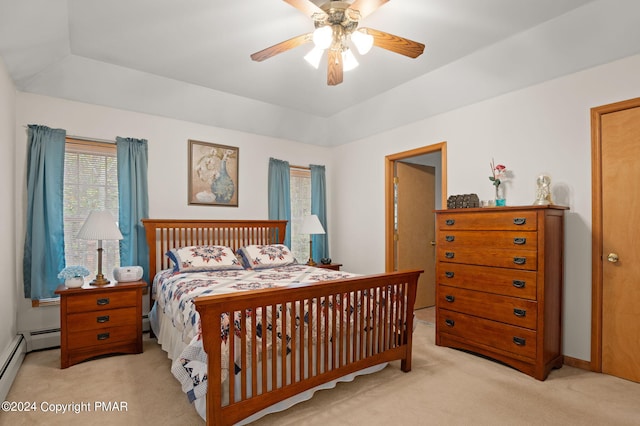 carpeted bedroom with a tray ceiling, a baseboard radiator, a ceiling fan, and baseboards