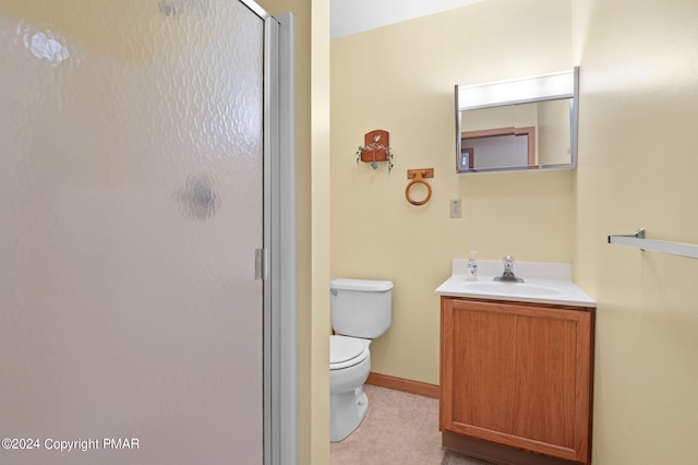 bathroom with baseboards, a shower stall, toilet, and vanity