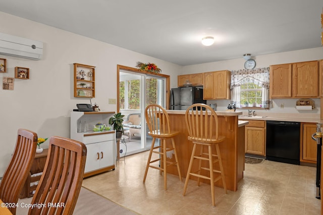 kitchen with a breakfast bar, a wall mounted air conditioner, light countertops, black appliances, and a sink