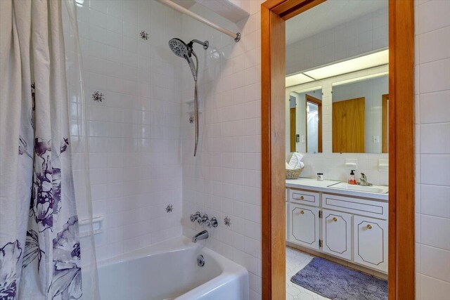 full bath with tasteful backsplash, vanity, and shower / tub combo with curtain