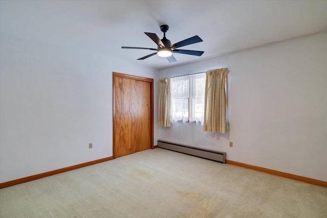 unfurnished bedroom with baseboards, a ceiling fan, light colored carpet, baseboard heating, and a closet