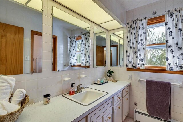 bathroom featuring a baseboard radiator, tile walls, and vanity