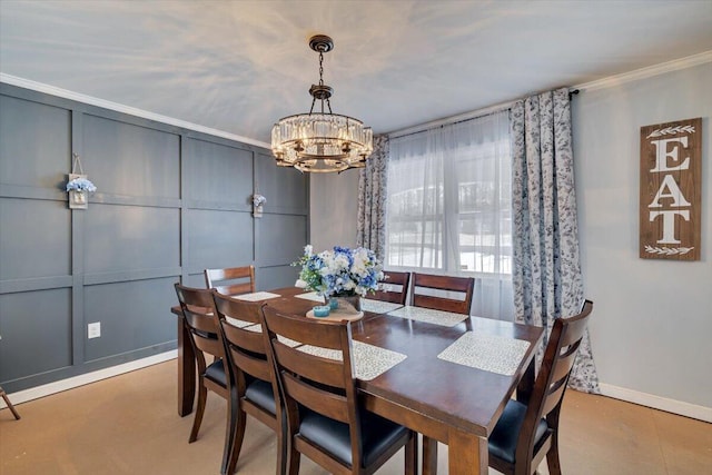 dining area featuring crown molding, a chandelier, a decorative wall, and baseboards