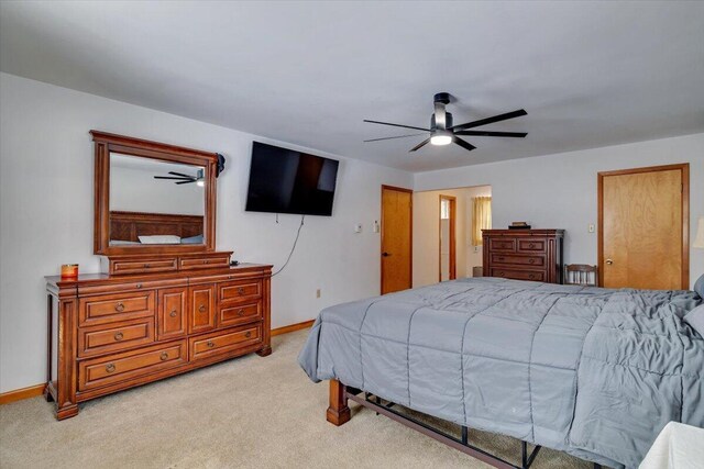 bedroom with light carpet, ceiling fan, and baseboards