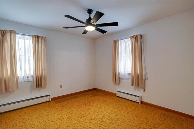 empty room with a baseboard heating unit, plenty of natural light, and baseboards