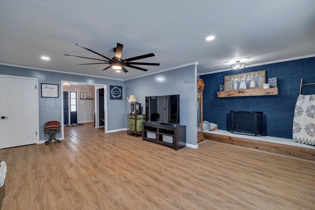 living area featuring ceiling fan, a fireplace, wood finished floors, and baseboards