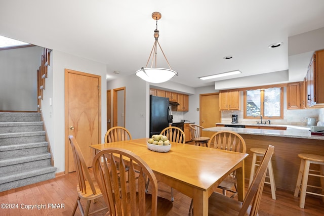 dining area featuring stairway and light wood-style flooring