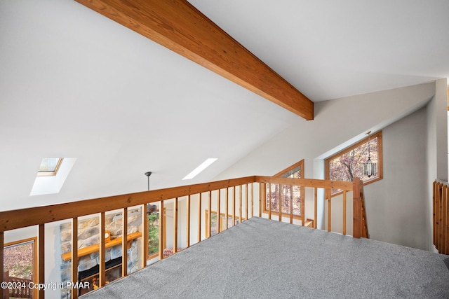 hall featuring carpet and vaulted ceiling with skylight